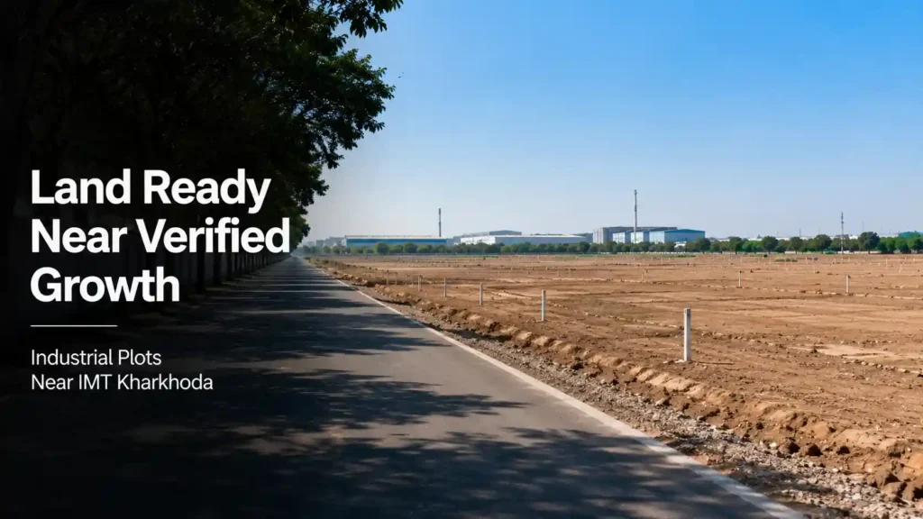 Open industrial plot with access road and distant factory silhouettes near IMT Kharkhoda